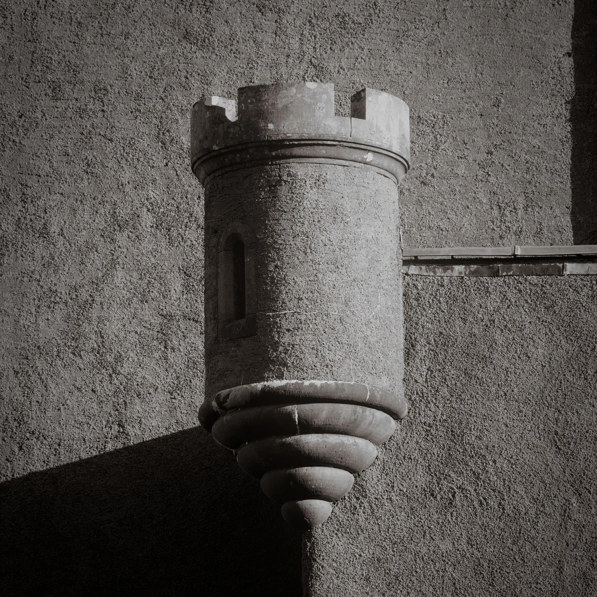Turret, Dunvegan Castle, Isle of Skye. This castle in Scotland, the seat of Clan MacCleod, is the oldest continuously inhabited castle in Scotland. The photograph is a minimal composition of shadow and light, highlighting the simple architectural for