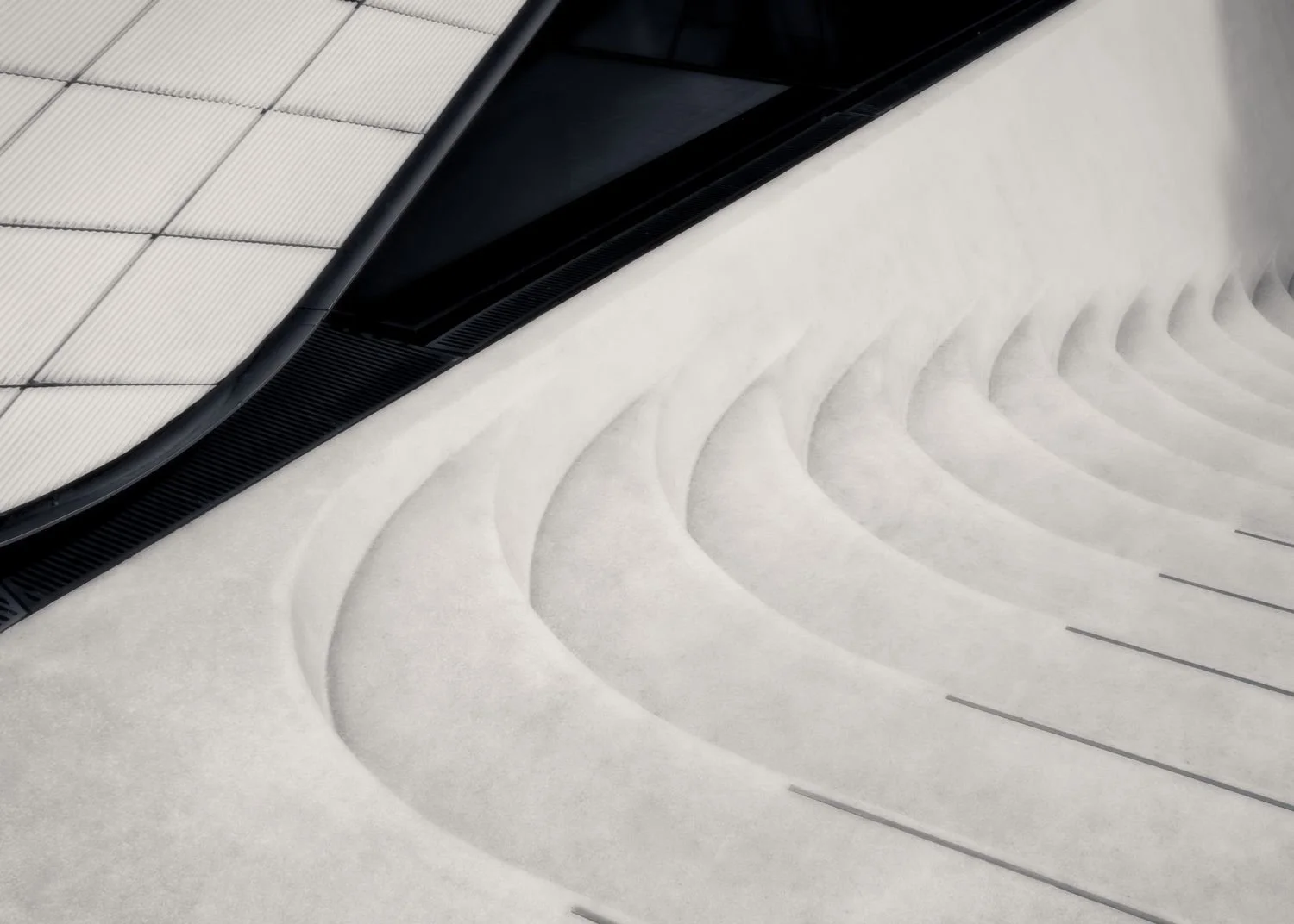 Staircase at the Sackler Wing, Victoria & Albert (V&A) museum, London. An abstract photograph of the stairs, showing their curved junction with the wall of the gallery.