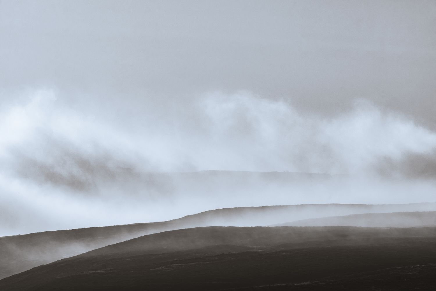 Cloud rising, Haworth Moor, Yorkshire, England. A monochrome photo with a minimal composition shows morning cloud rising from the rolling hills.