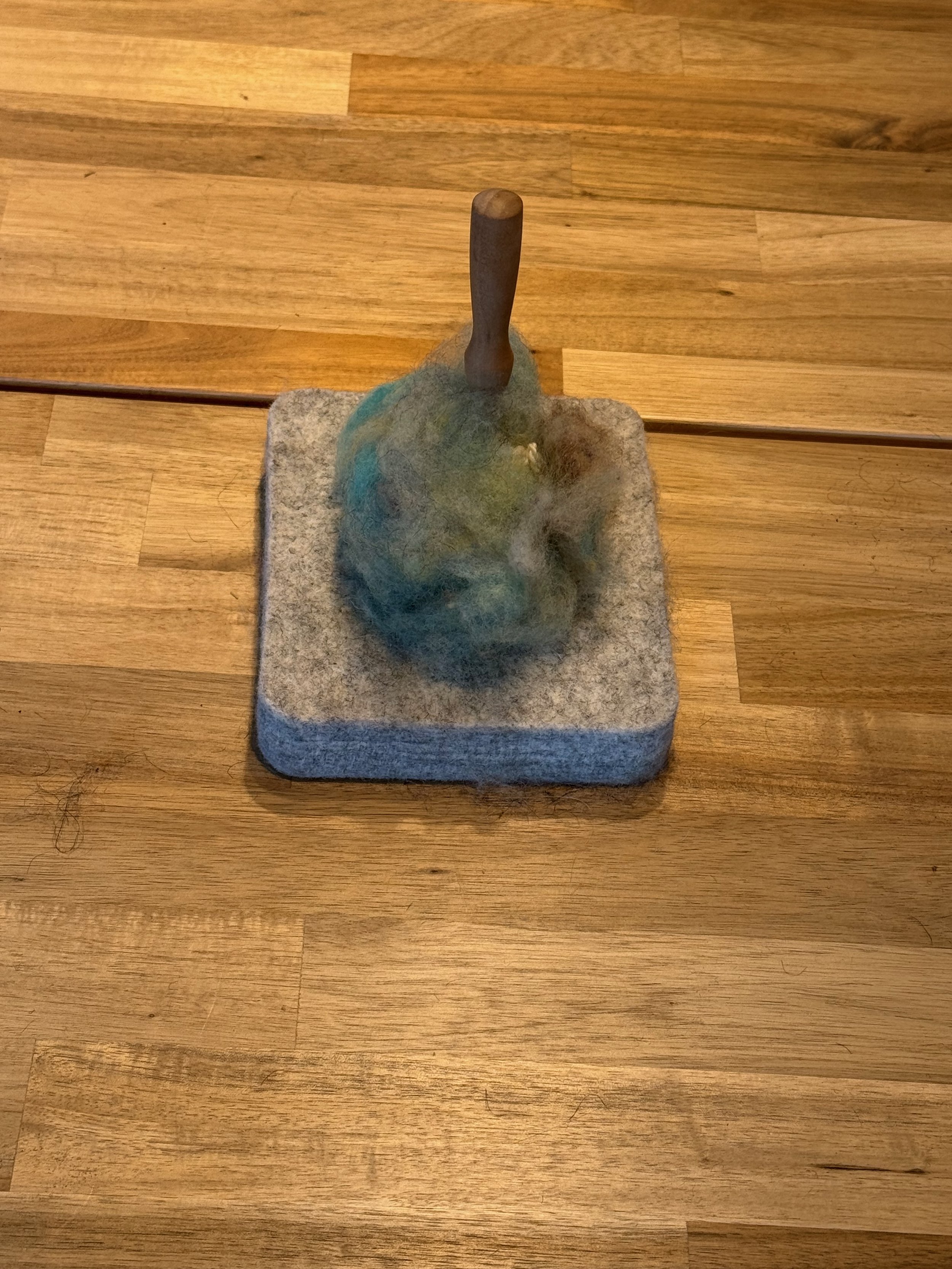 needle felt loose fiber to the ball wrapped in yarn