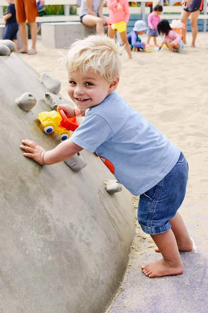 Aiden learned how to climb this rock at Annenberg Beach during the party which made him so happy! 