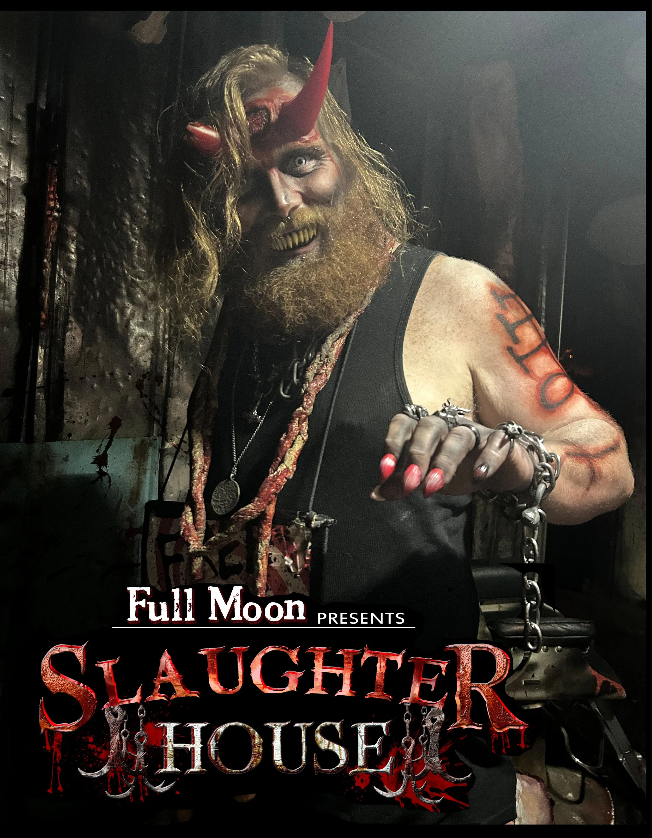 A person in dark makeup with a horror-themed costume, wearing a faux blood-stained black tank top, has chains around their neck and wrists, and face makeup with a gruesome, monster-like appearance. The background appears to be a dark, industrial sett