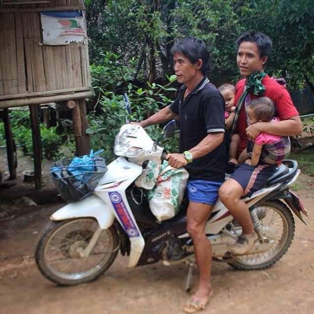 A baby tucked under each arm and off they go. 
Looks like it's Dad's turn to look after the children today at May La Oon. It's common to see a sleeping baby in a hammock or tied to a parent's back while they work. With food rations being cut in the r