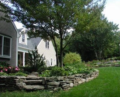 Stone retaining wall for raised planting bed and stone steps