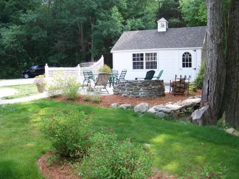 Stone retaining wall with custom fireplace, patio and custom fence