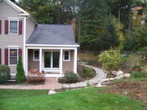 Custom addition with open porch, site stone walls and stone steps, plantings