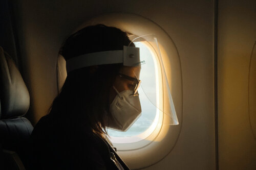 在飞机上戴口罩由unsplash上的camila perez拍摄