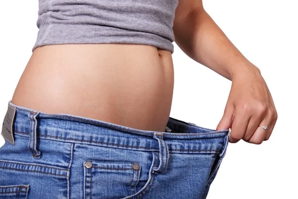 picture of white woman in jeans with belly showing weight loss