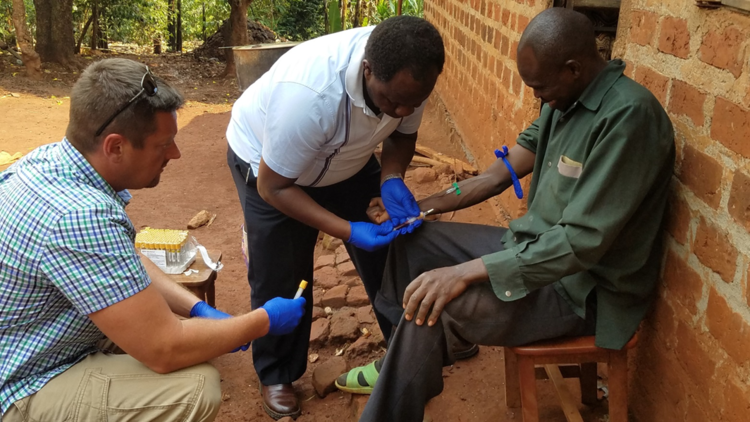 John Dye, left, and his team from the U.S. Army Medical Institute of Infectious Diseases at Fort Detrick took blood samples from Ebola survivors with the help of Ugandan researchers like Dr. Julius Lutwama, center, of the Uganda Virus Research Institute.