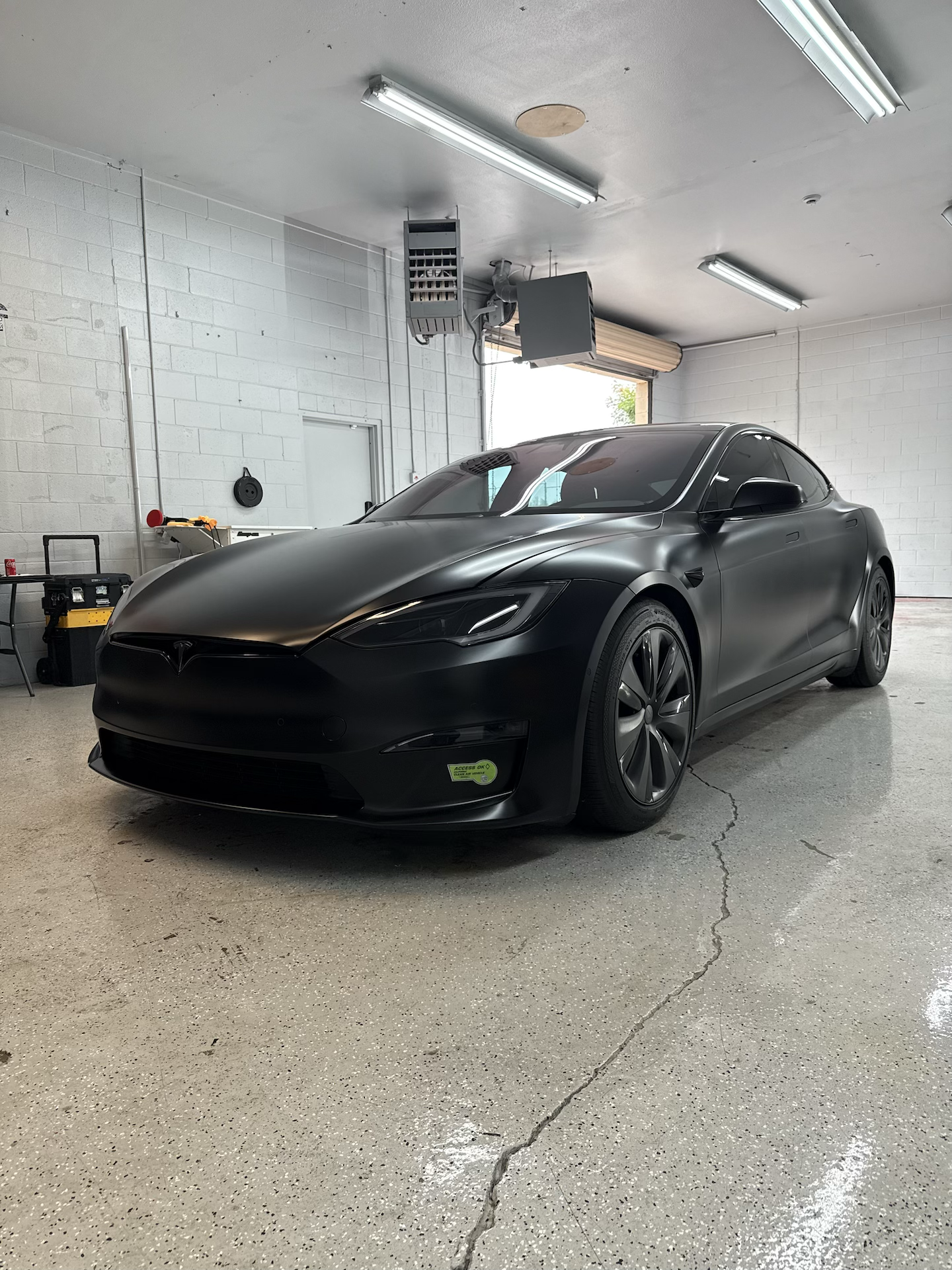 Tesla model S parked in Honest Tint shop during installation of full vehicle protection WITH XPEL STEALTH  paint protection film