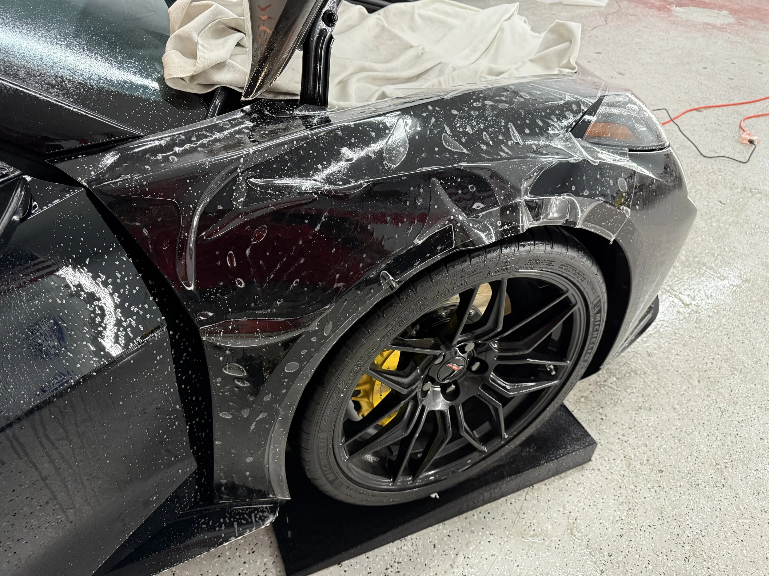 XPEL paint protection film installation on fender of a 2025 corvette Z06 by Honest Tint & PPF 33111 Yucaipa blvd Yucaipa ca 92399.