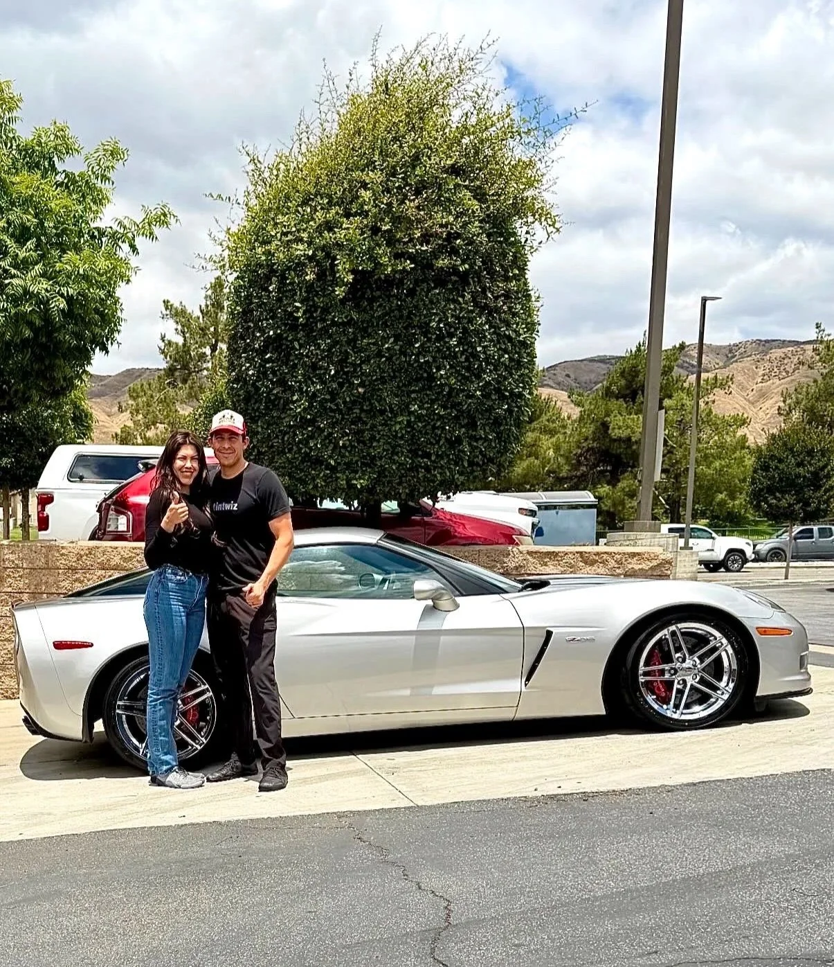 Danny and Liz owners and installers for Honest Tint & PPF in front of a Corvette track vehicle they just installed paint protection film and windshield protection film