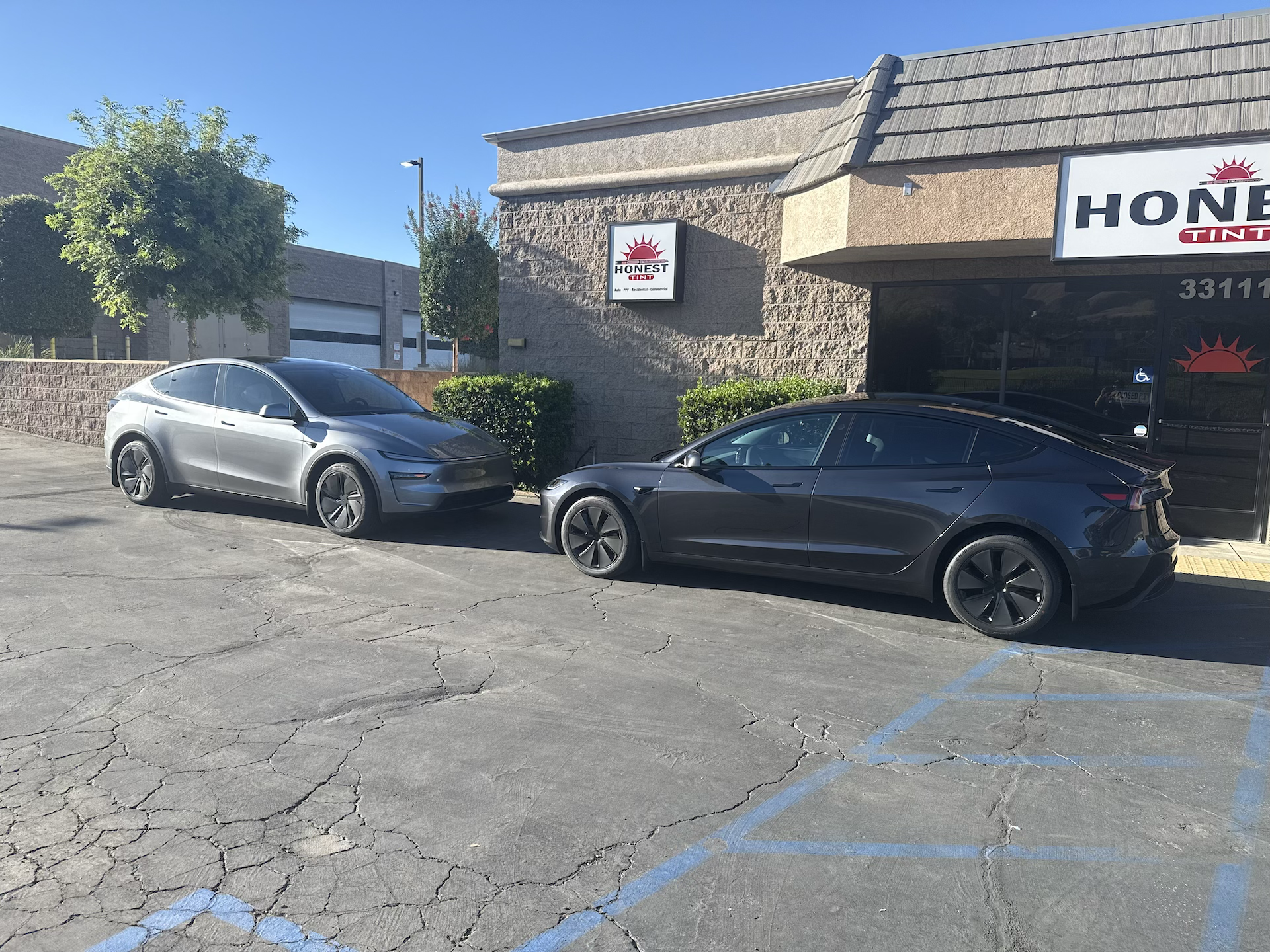 Tesla model Y and Tesla model 3 full front coverage plus doors installation using XPEL ULTIMATE FUSION paint protection film parked outside at honest tint in Yucaipa ca