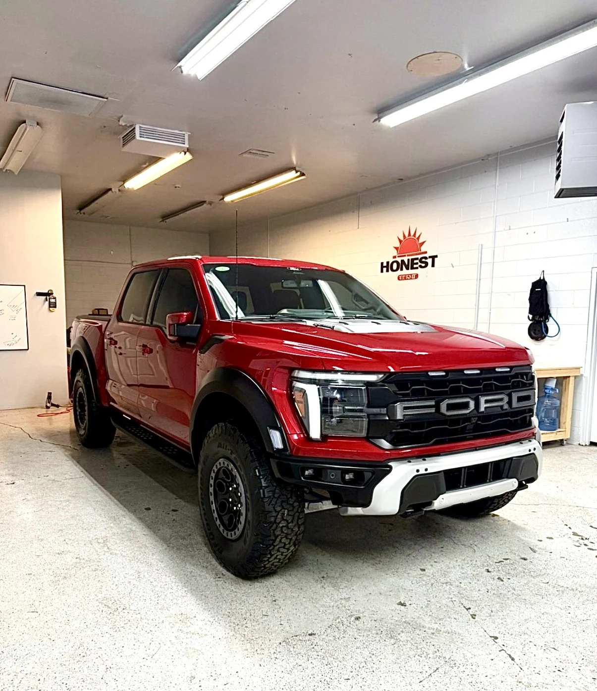 Close-up of the front of a red car with front-end installation of clear PPF installed by honest tint and ppf located in yucaipa ca. 