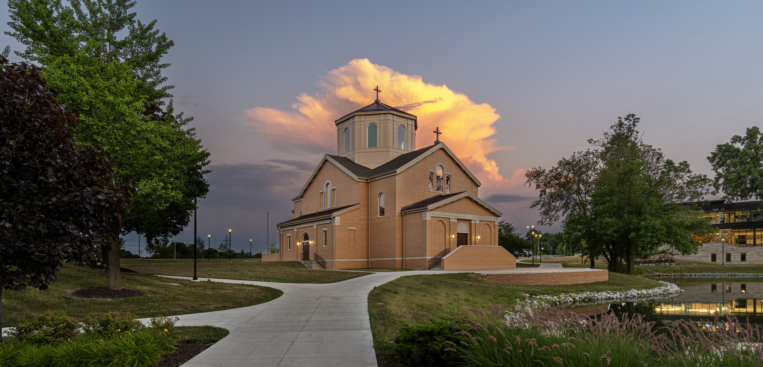 A photography of an isolated church in front of a yellow cloud.