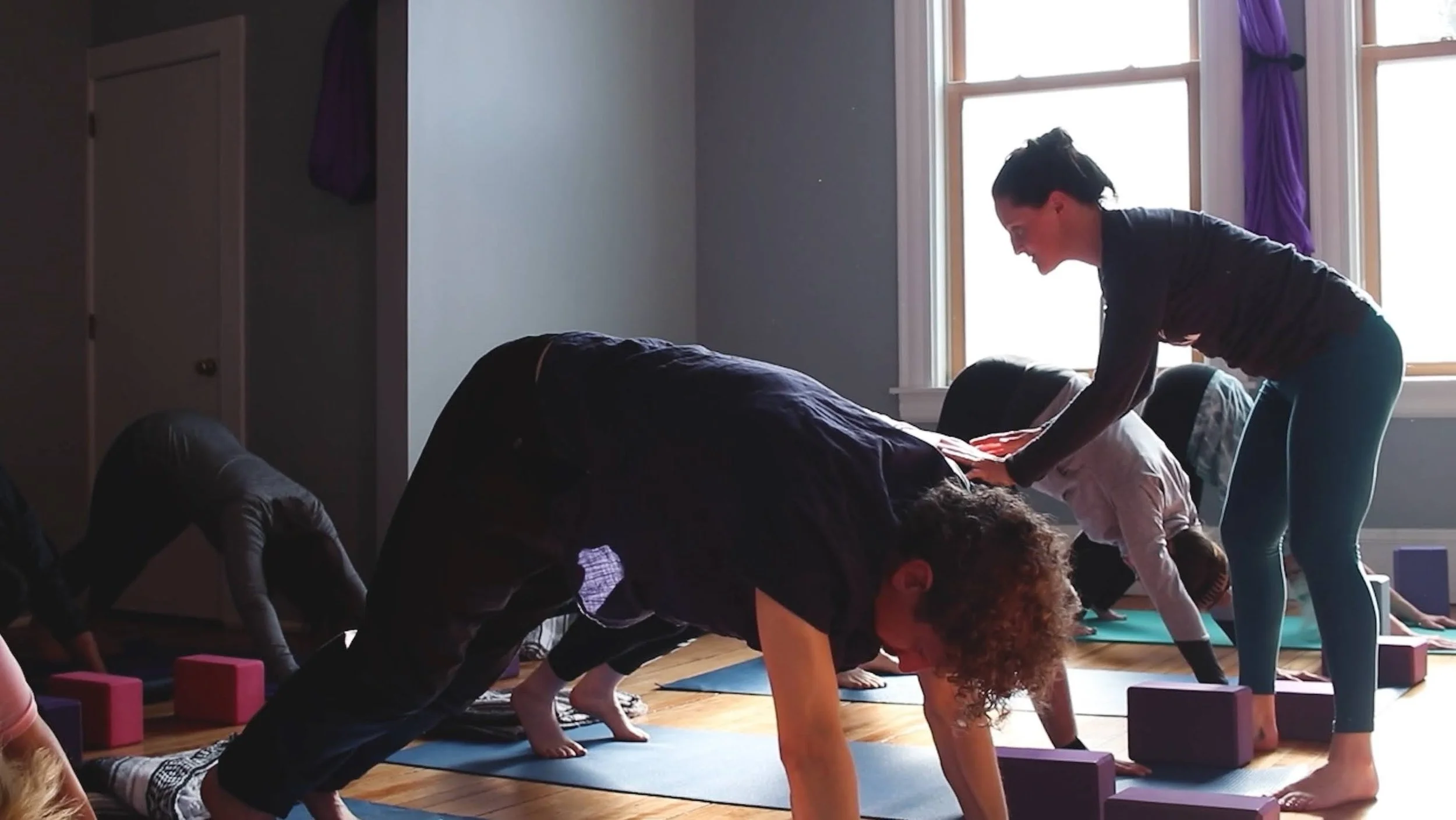 Leah Titcomb teaching hands-on yoga assists in Brunswick, Maine