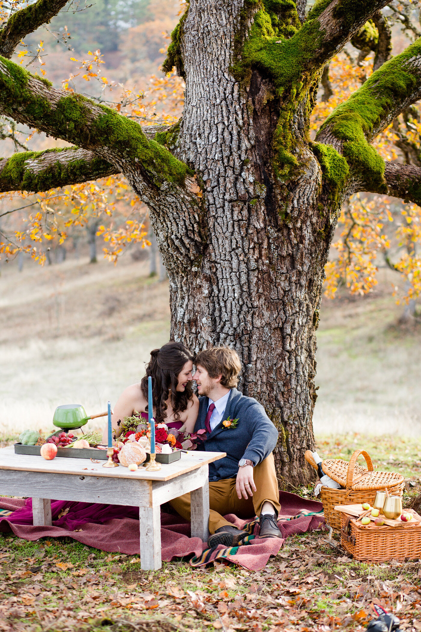 Eloping couple under large oak tree with delightful picnic table