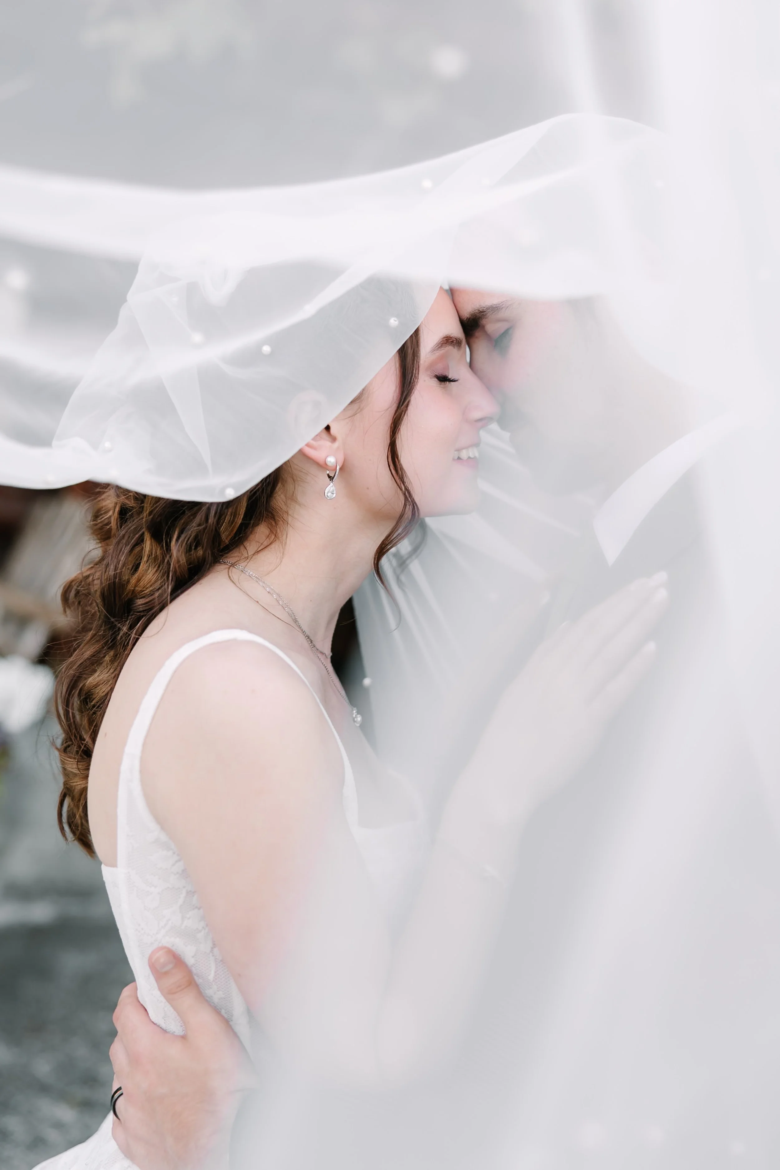 A bride on her wedding day with a veil obscuring her husband.