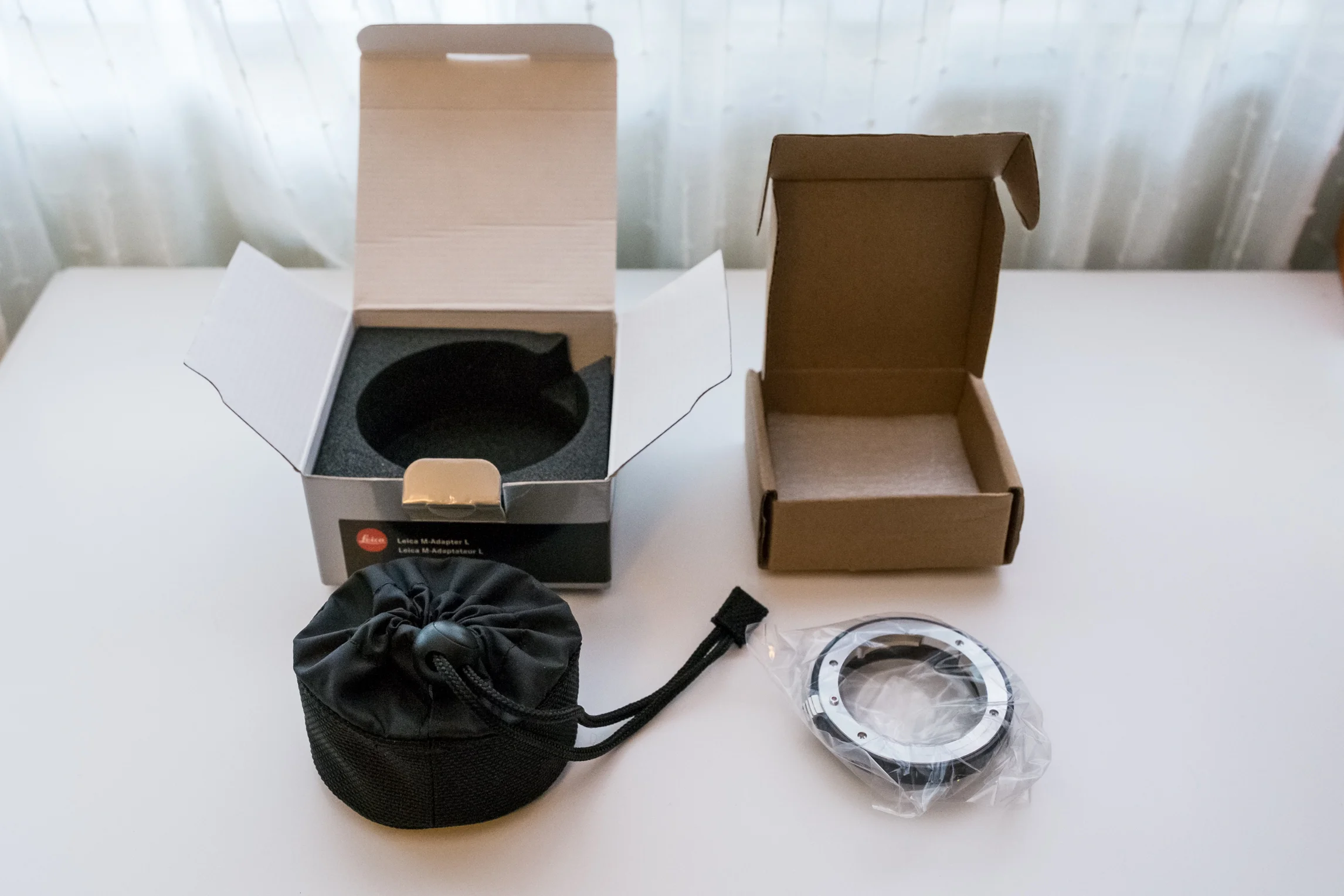 Notice the nice adapter case/bag found on the Leica version with a draw-string cinch mechanism