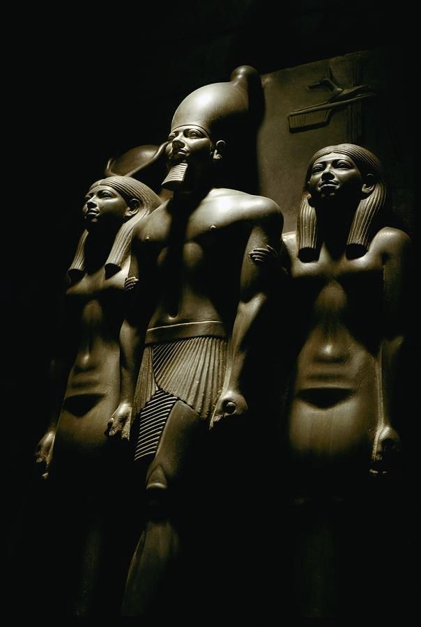 Pharaoh sandwiched between the goddess Hathor and patron god of Thebes