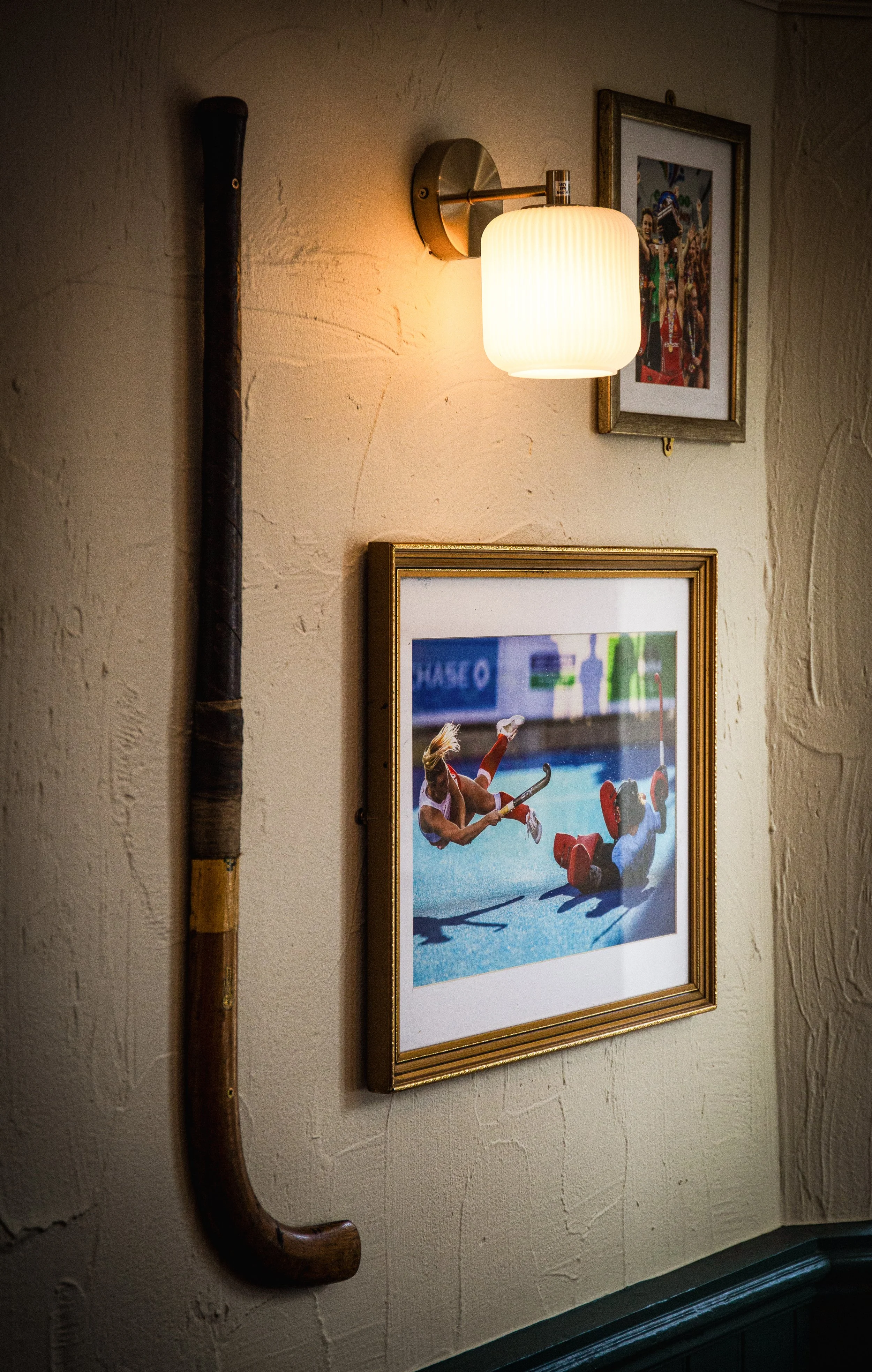 Wall of grass hockey images with a vintage hockey stick