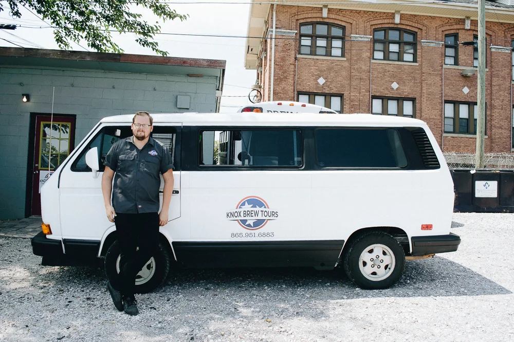 Zack standing in front of his VW Bus, nicknamed "Scruffy".