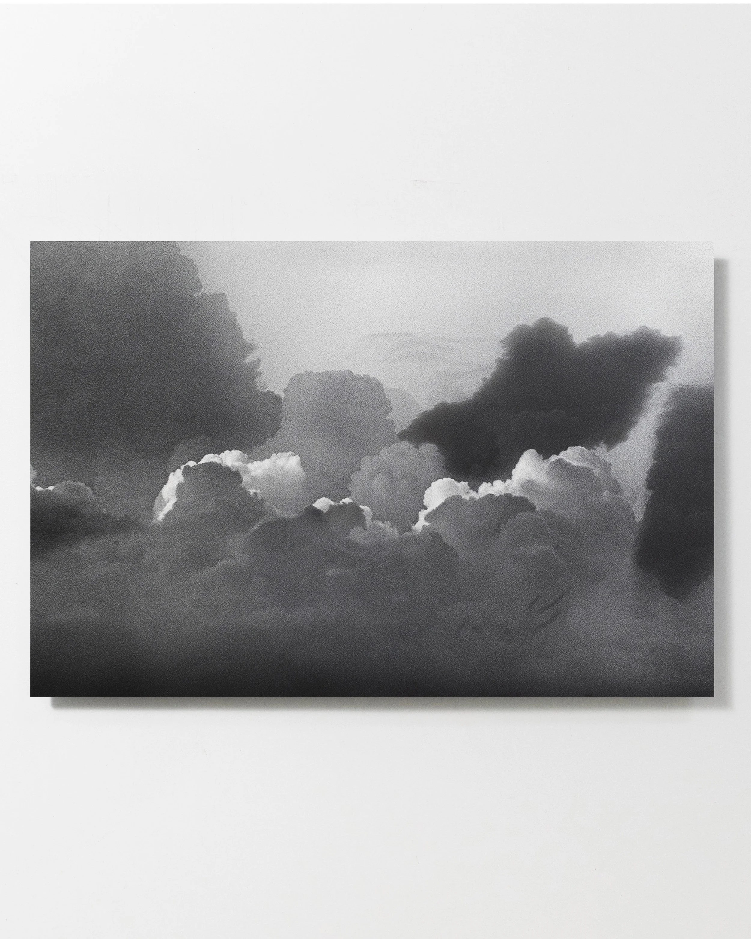 Black and white photograph of a cloudy sky with various cloud formations and shading.