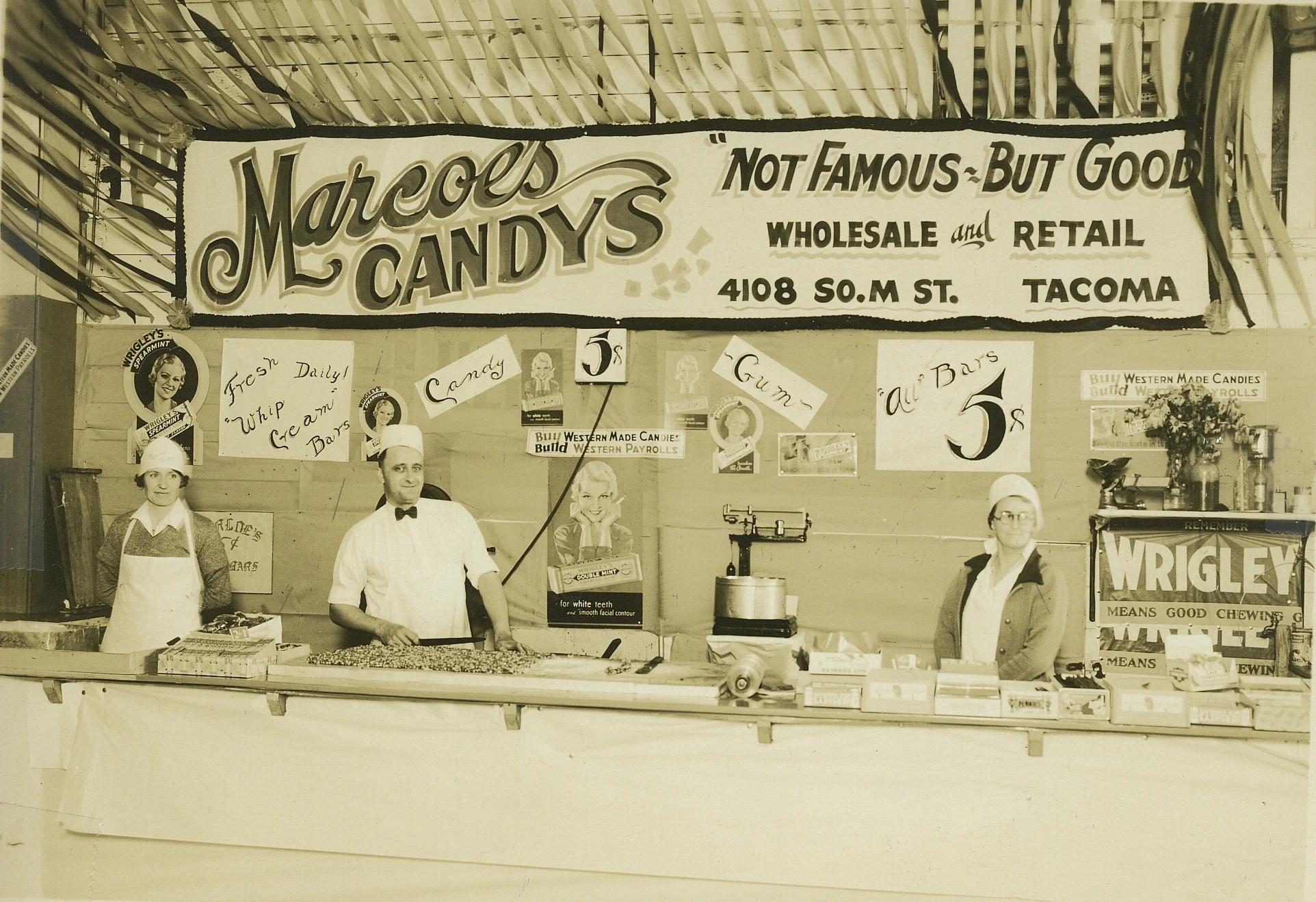 Founders Dora Marcoe (Left) and Floyd Marcoe Sr. (Center) at the original Marcoe's Candy stand at the Washington State Fair circa 1930. The original company slogan was "Not Famous - But Good"