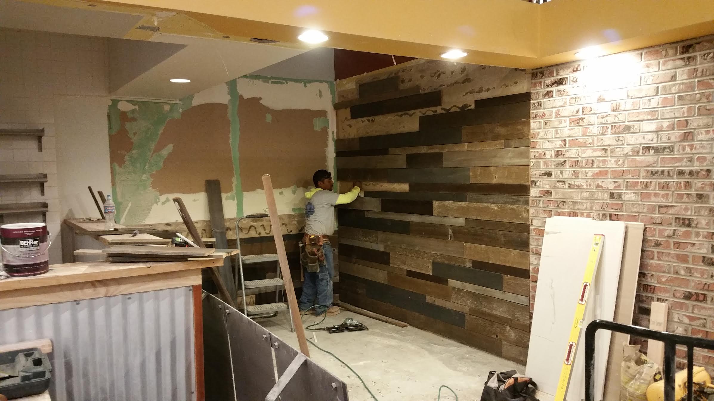 Installation of hand-stained and cut reclaimed wood