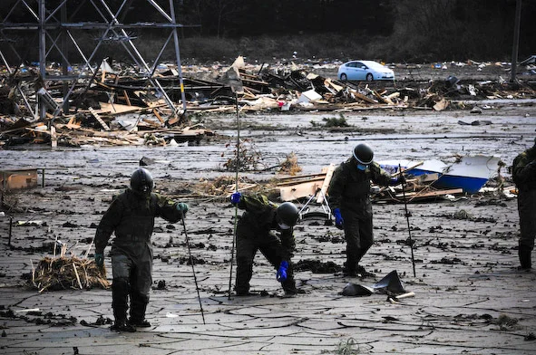 Rescue volunteers scour the mud in Fukushima for the deceased.