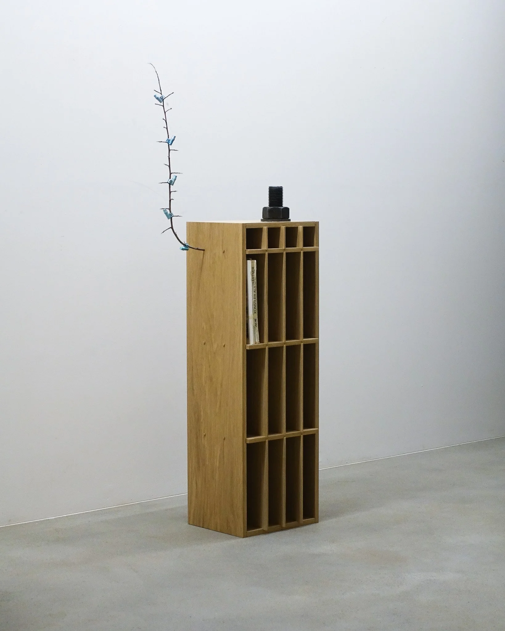 Malik Jeannet, Künstler als Gärtner, 2026, chêne, éléments récupérés (vis, livre, branche, étui pour colombogramme), 136 x 27 x 48 cm