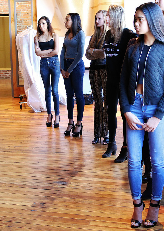 Models lined up for role call and run throughs with their designers and the KCFW Committee.