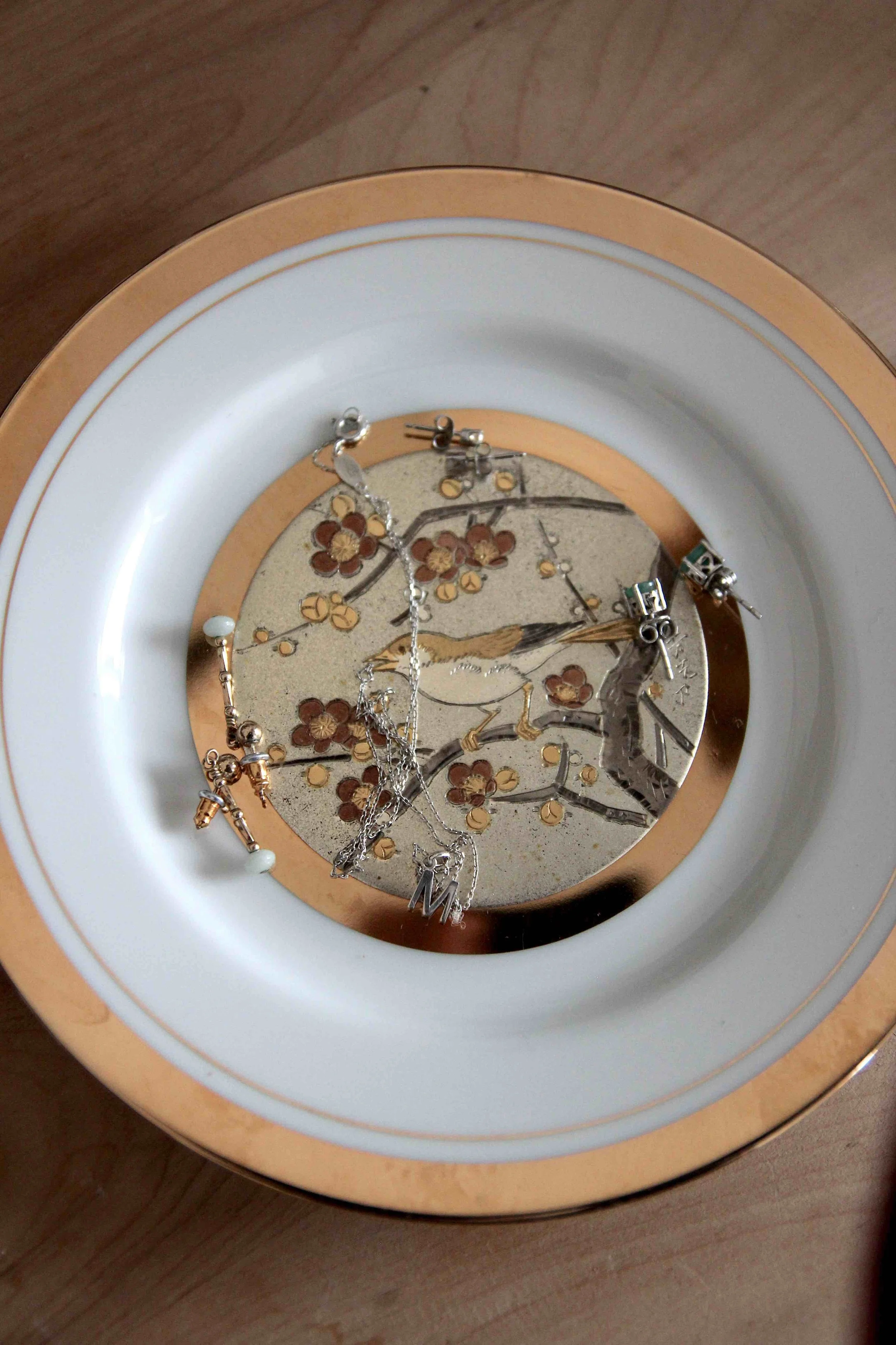 A vintage-style bird plate holding jewelry on a dresser, used as an intentional corner for manifestation. The bird symbolizes the writer’s voice and the journey of healing through creative expression in 2026.