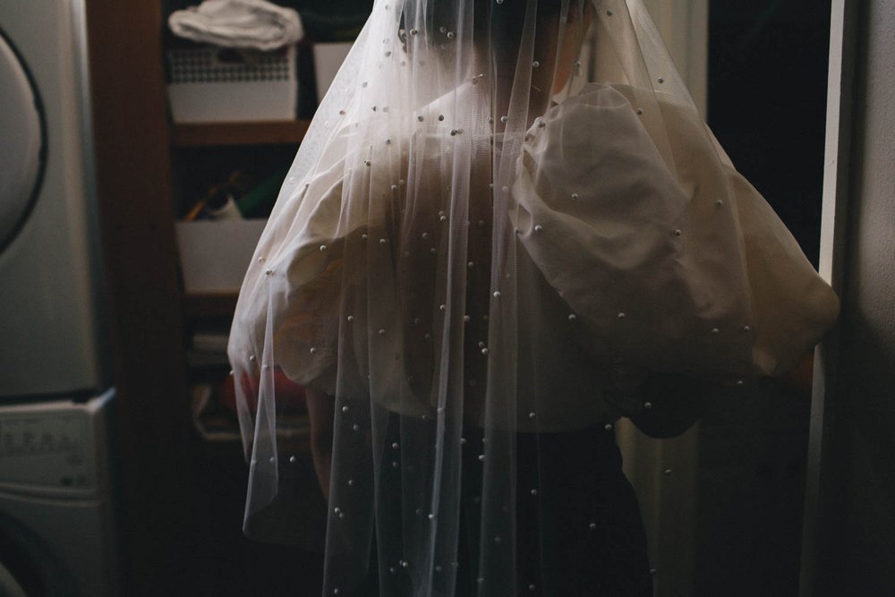 light filtering through a bride's veil as she gets ready for her wedding ceremony