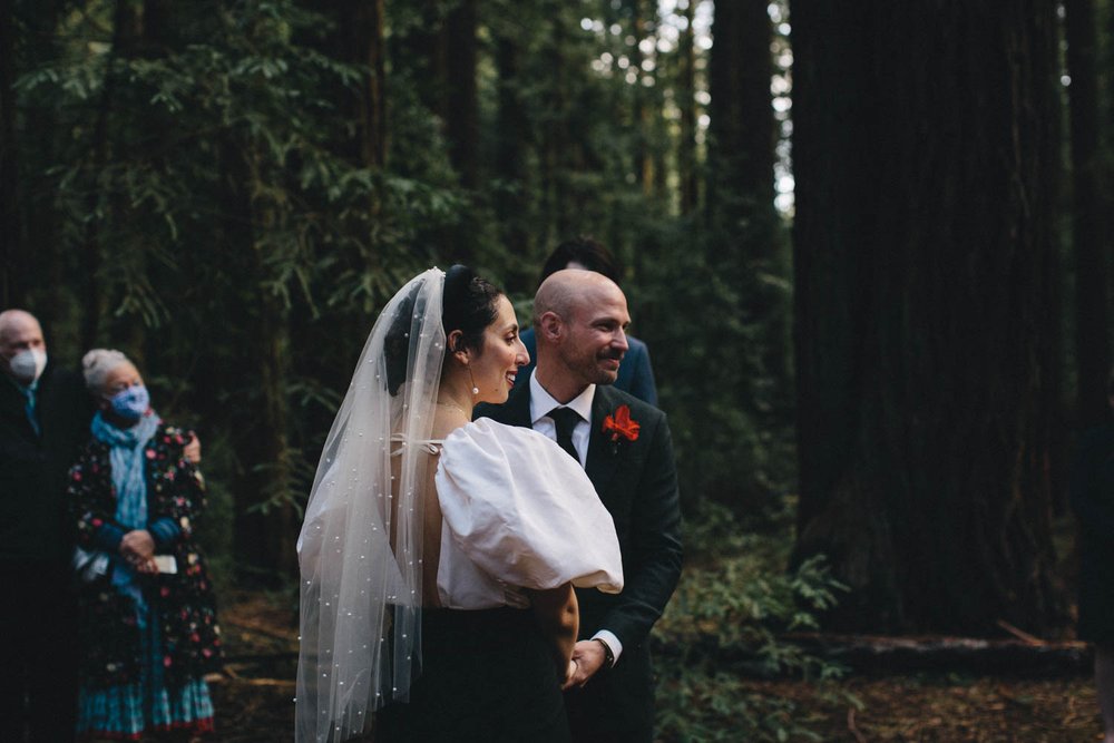 a wedding ceremony in a forest of redwoods at joaquin miller park in oakland