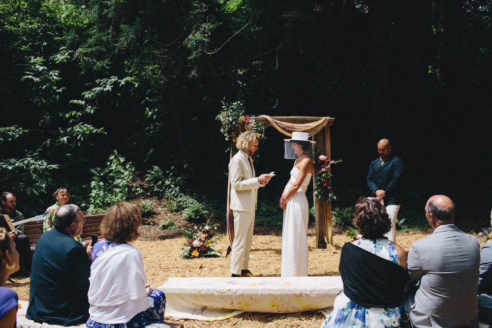 a bride and groom reading their vows during their wedding ceremony at the san francisco botanical garden