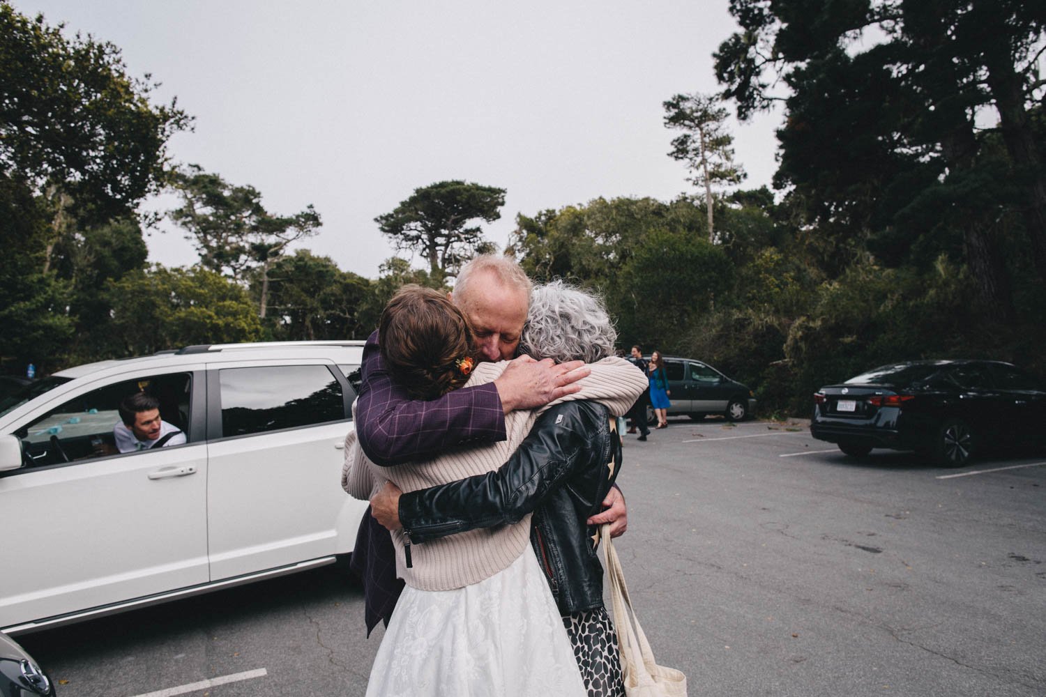 bride hugs her parents after her wedding ceremony