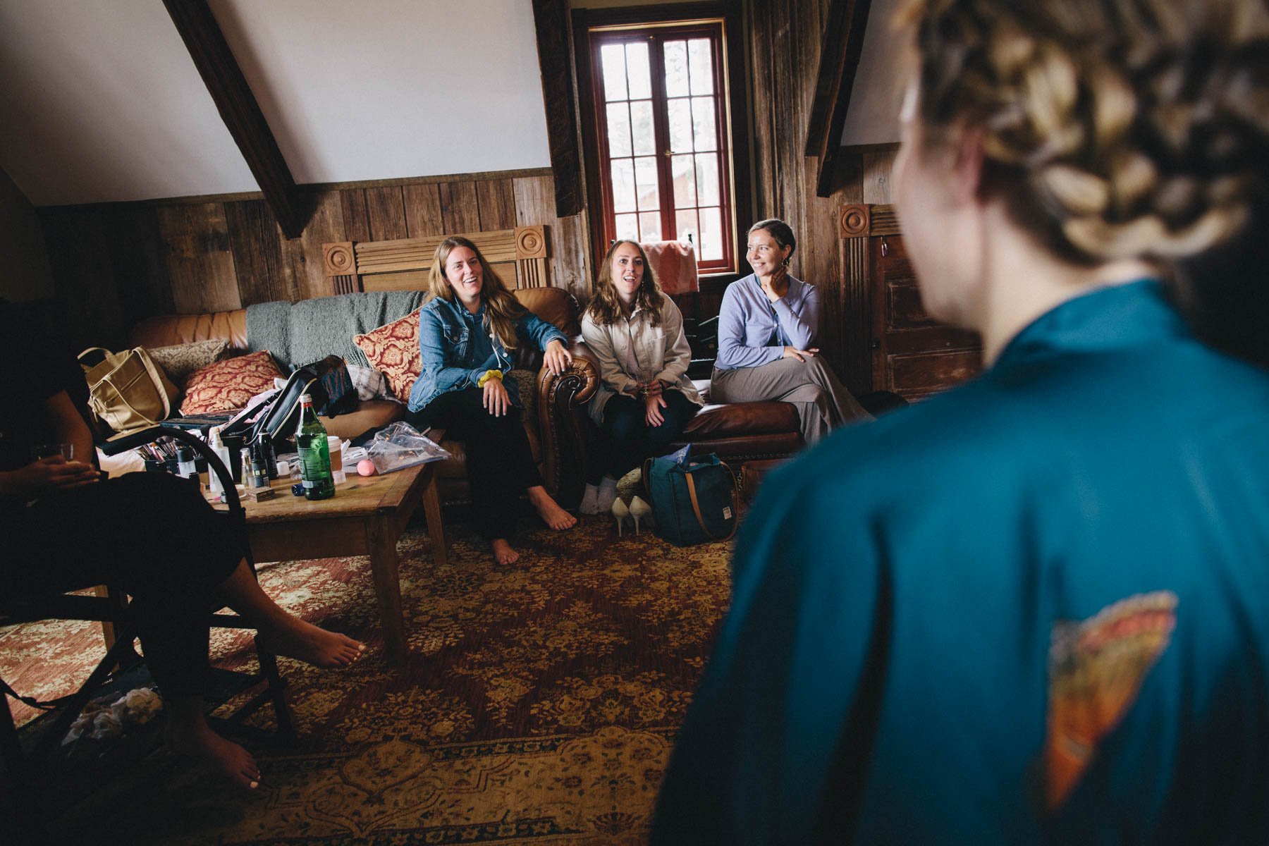 A bride's friends watch her getting ready at Spring Ranch