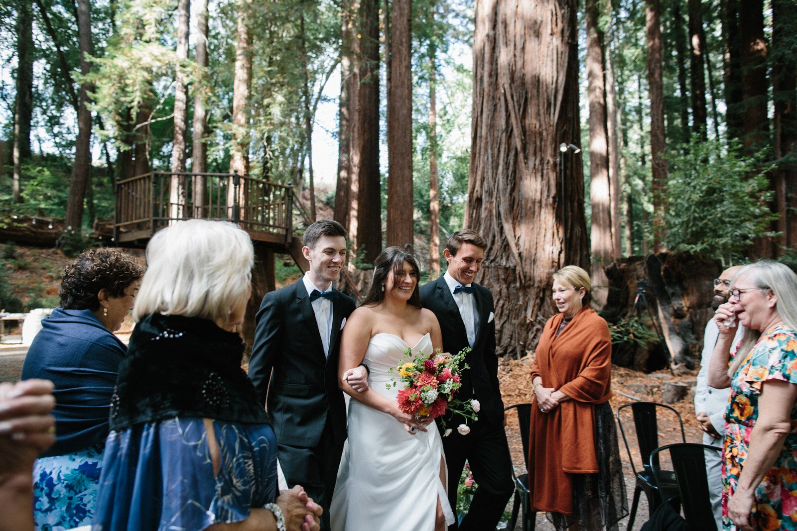 Bride walks down the aisle with her brothers at The Brambles in Mendocino