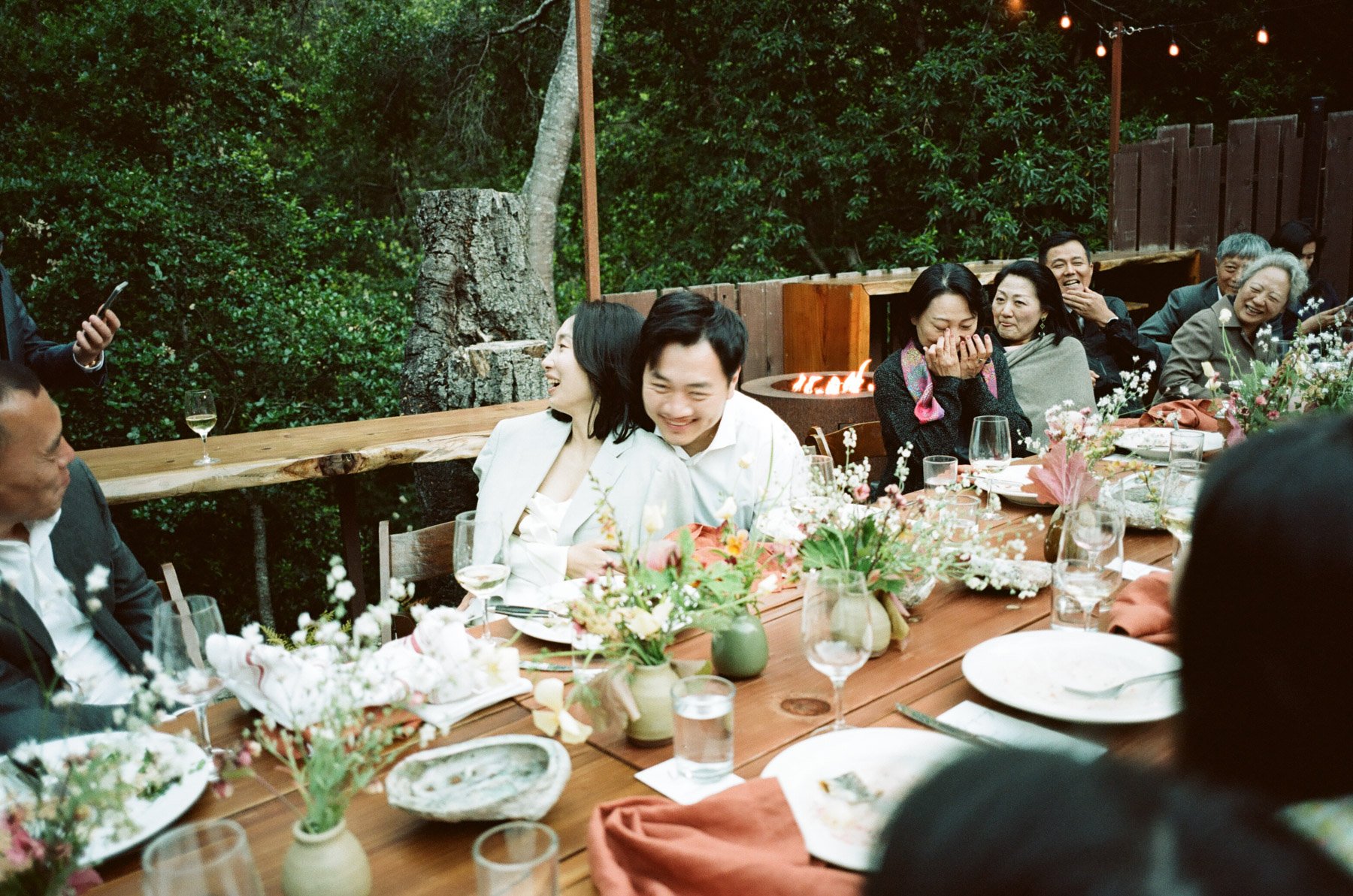 A couple listens to family toasts at their wedding reception in Big Sur