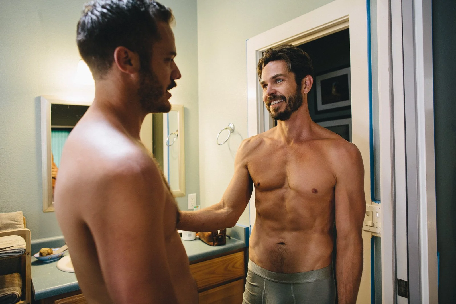 Grooms share a moment while getting ready for together for their wedding