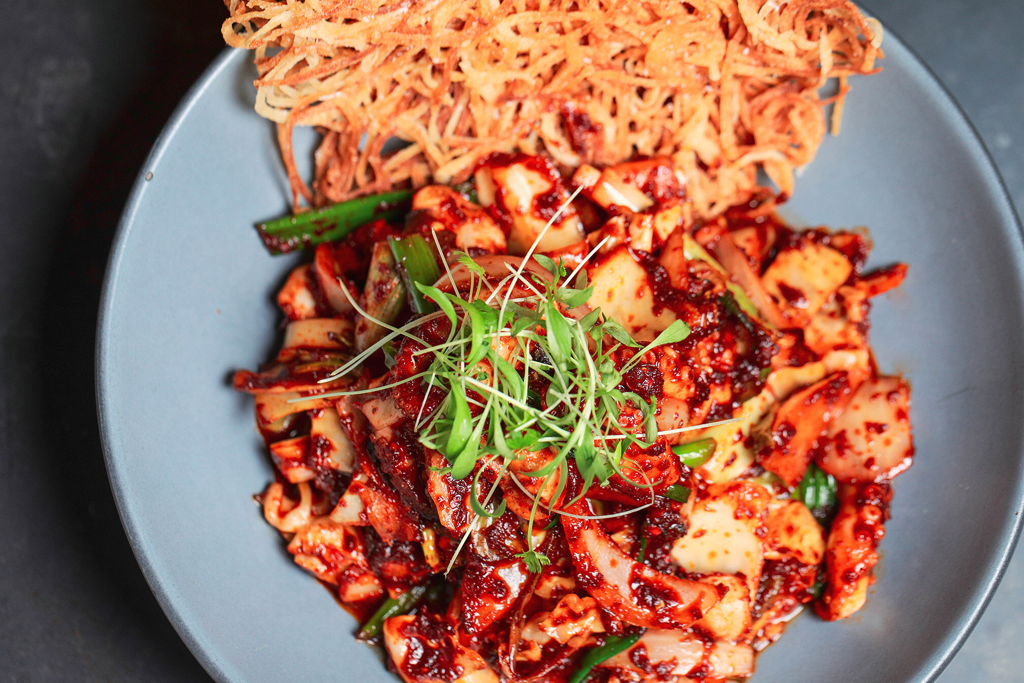 This spicy Baby Octopus(쭈꾸미 볶음) is one of the winter season's favorite bar food in Korea. It's known to be excellent for pairing any kind of drink, made with baby octopus, bird&rsquo;s eye chili, onion, micro cilantro, and potato nest. Enjoy pairing 