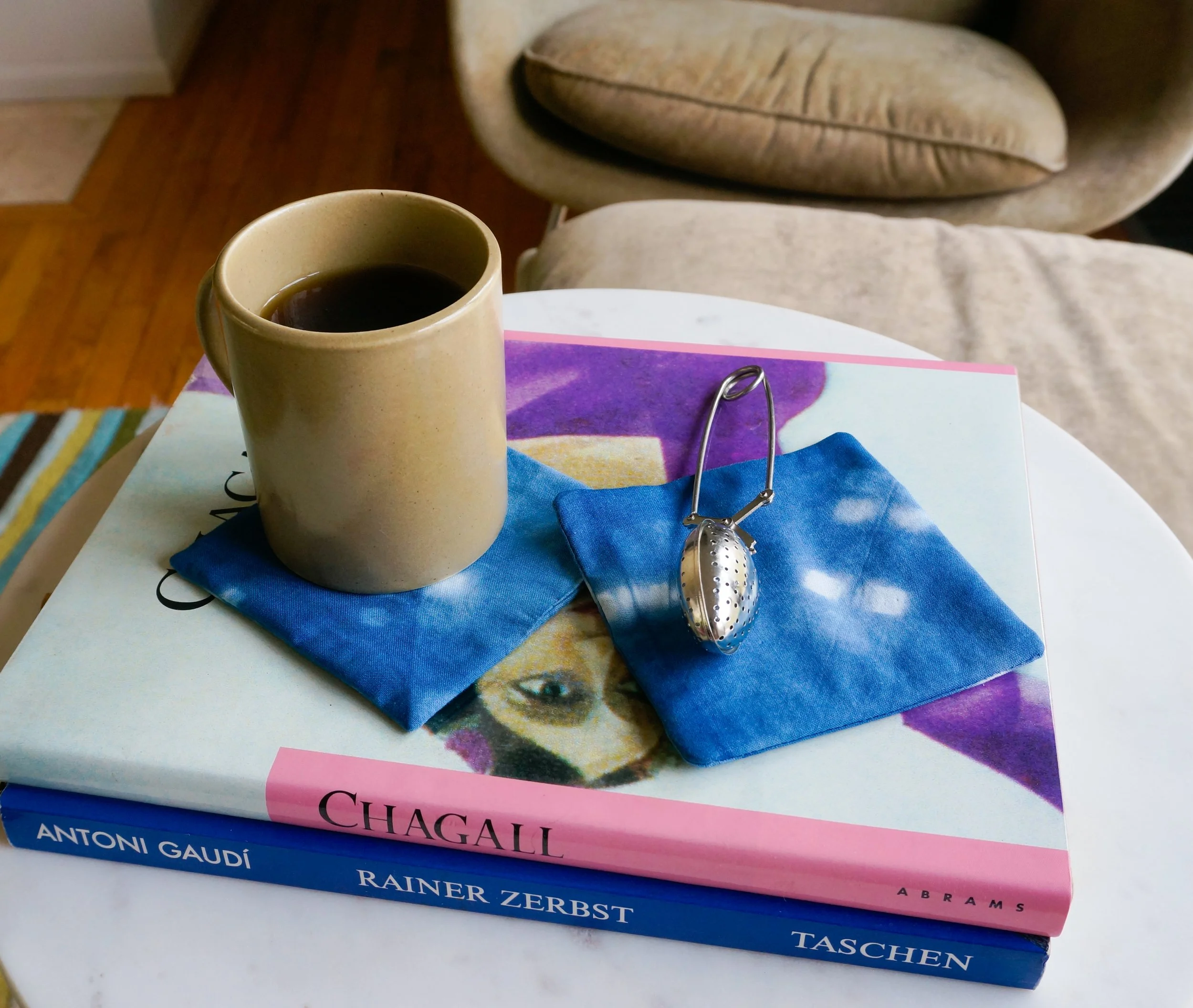 hot tea in a mug on an indigo coaster on top of books