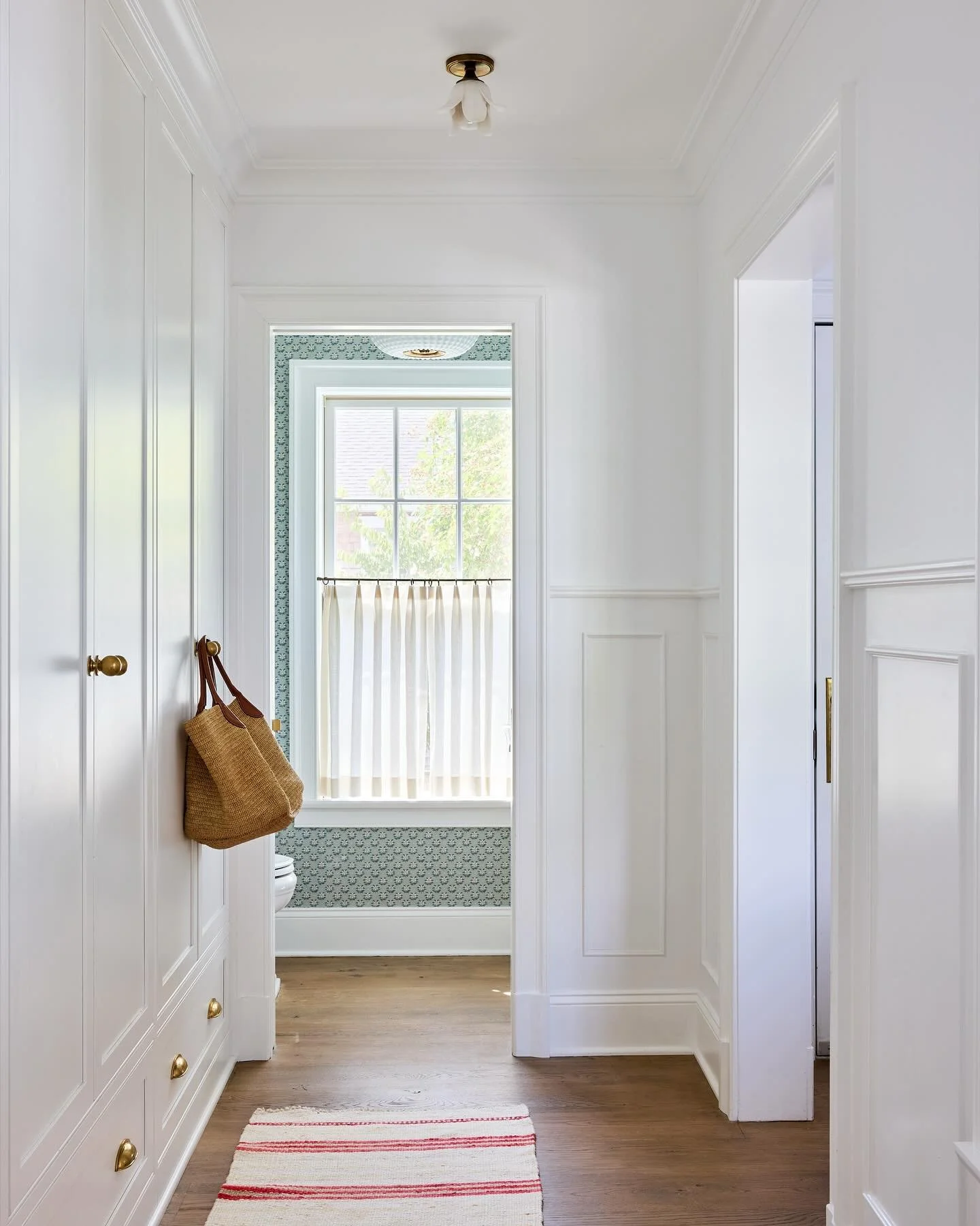 A thoughtfully designed hallway mudroom maximizes storage for a young active family, and leads to the loveliest jewel box of a powder room 💙
