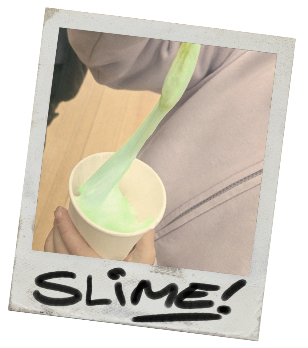 Person holding a cup of green slime with slime stretching out of the cup, labeled 'SLIME!' in black marker.