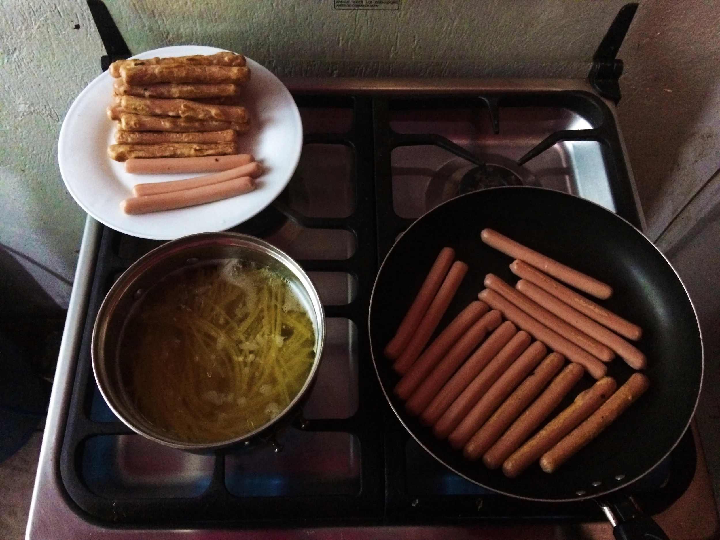 A typical night of food prep. Pasta for dinner, and pre-cooking chicken sausages for protein on the go for long bus journeys.