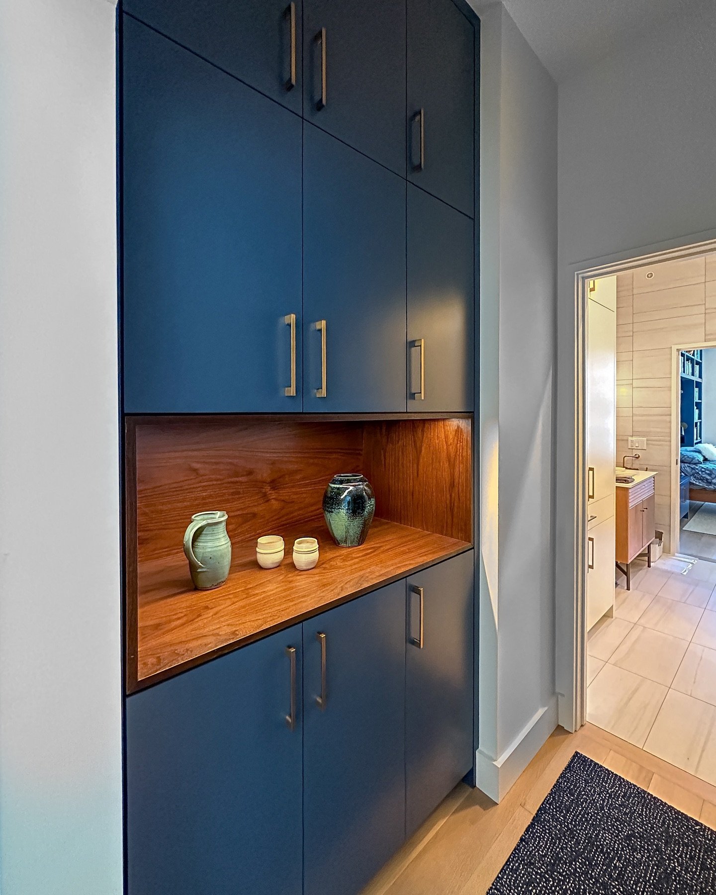 Think hallways serve only as connectors between rooms? Our Colfax Condo project proves the contrary, elevating this hallway with beautiful blue cabinets and an open display. The blue hue is carried over from the kitchen, with seamless styling to ensu