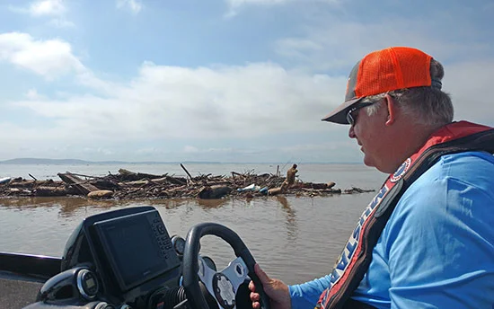 Pete Gluszek of Bass University checks out the floating debris caused by flash flooding on the Chesapeake after the Elite Event was cancelled there last week. 