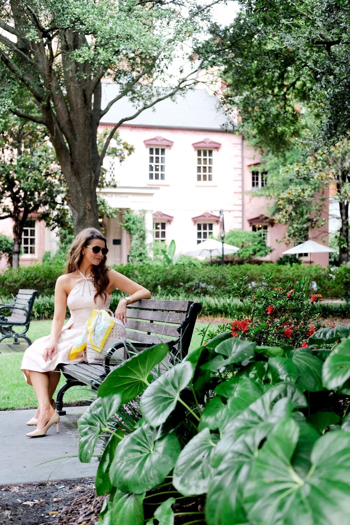Brenna Lauren on bench outside of Olde Pink House in Gal Meets Glam blush pink dress