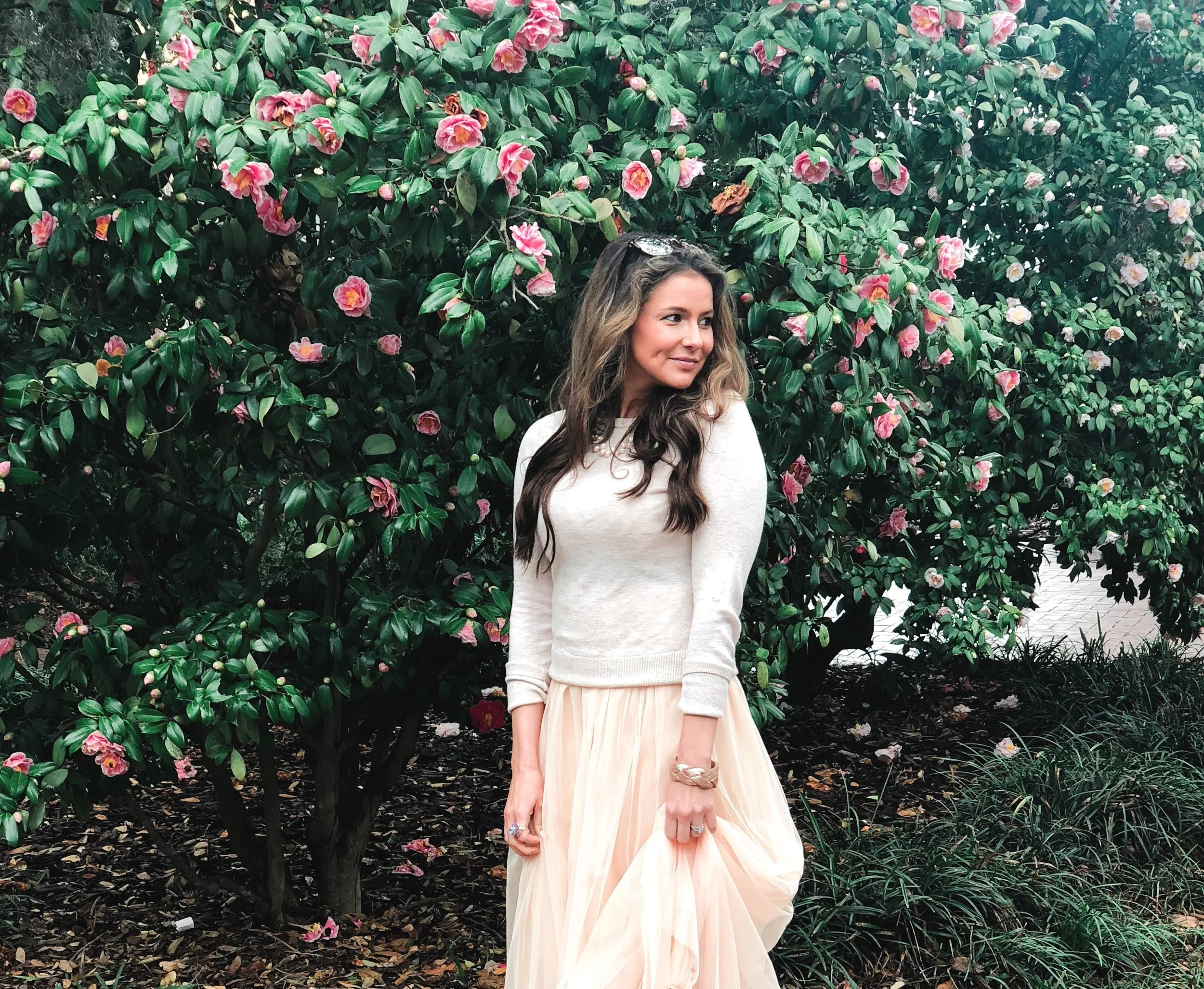 Savannah in the Spring, Brenna Michaels stands next to a blooming Camellia bush